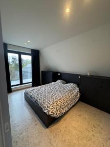 a bedroom with a bed in a room with a window at The Corner-GILBERT in Oedelem