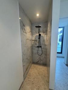 a bathroom with a shower with a stone wall at The Corner-GILBERT in Oedelem