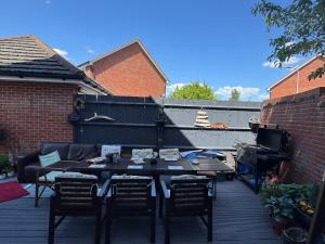 a patio with a table and chairs on a deck at Chrysanthemum Drive stays in Shinfield
