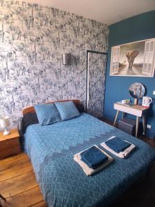 a bedroom with a bed with a blue comforter at chambre dhote condat sur ganaveix in Condat-sur-Ganaveix