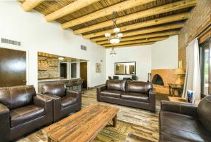 a living room with leather furniture and a wooden ceiling at Tanque Verde Guest Ranch in Tucson