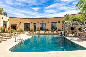 a swimming pool in front of a building with a patio at Tanque Verde Guest Ranch in Tucson