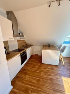 a kitchen with white cabinets and a wooden floor at Inselhus in Burg auf Fehmarn
