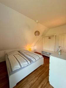 a bedroom with a white bed in a room at Inselhus in Burg auf Fehmarn +6 photos