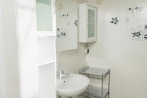 a white bathroom with a sink and a mirror at Ferienlodge bei den Reben in Sankt Margarethen im Burgenland +32 photos