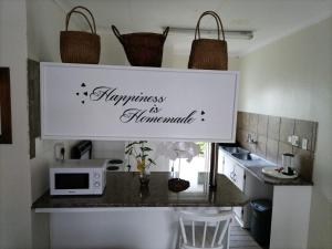 a kitchen counter with a sign that says happiness is homemade at Eskulaap Hotel in Polokwane