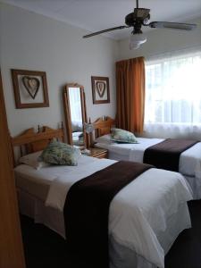 a hotel room with two beds and a mirror at Eskulaap Hotel in Polokwane