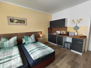 ein kleines Schlafzimmer mit Bett und Küche in der Unterkunft Doppelappartement CityImmo in Gotha