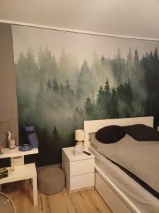 a bedroom with a pine forest mural on the wall at Eifelsteigzimmer Bruderherz in Gerolstein