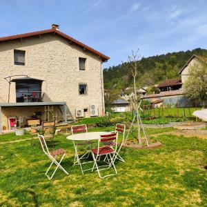 a table and chairs in the yard of a house at A l'ombre des vignes, chambres d'hôtes 3 épis avec piscine in Poncin