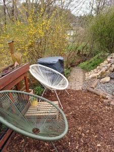a chair sitting next to a bench in a garden at Eifelsteigzimmer Bruderherz in Gerolstein +31 photos