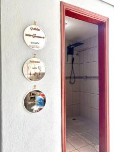 a bathroom with three plates on a wall with a mirror at Solar Boutique Residence in Pouso Alegre