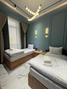 a bedroom with two beds and a chandelier at Shahzam Hotel in Samarkand