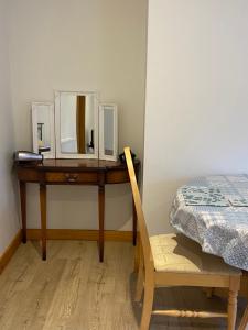 a dressing table with a mirror and a chair at The Cellar on Hornby in Morecambe