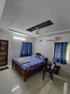 a bedroom with a bed and a chair in it at Elite stay villa in Vākalapūdi