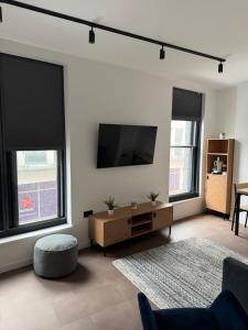 a living room with a flat screen tv and two windows at 70 Bath Street in Saint Helier Jersey