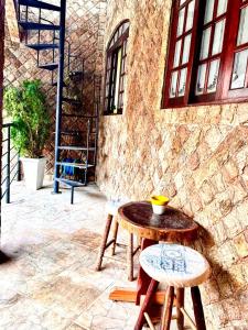 a table and two stools in front of a building at Solar Boutique Residence in Pouso Alegre