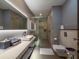 a bathroom with a sink and a shower and a toilet at The Lusso Hotel in Abuja +158 photos