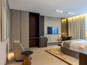 a hotel room with a bed and a television at The Lusso Hotel in Abuja