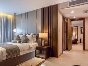 a bedroom with a bed and a lamp and a room at The Lusso Hotel in Abuja