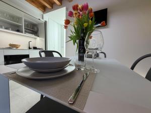 a table with a bowl and a vase of flowers on it at Donna Dina in Avola