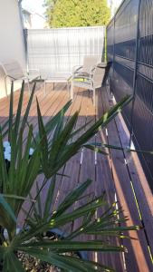 a wooden deck with two chairs and a plant at " Bulles et Evasion - Maison, Spa en option" in Ville-le-Marclet +5 photos