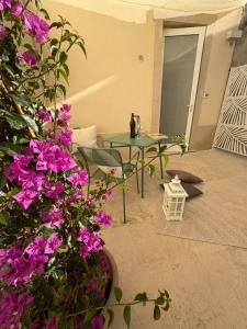 a patio with a table and purple flowers at Donna Dina in Avola