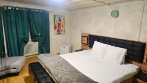 a bedroom with a large bed with green curtains at Zimmer perla in Chur