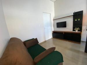 a living room with a couch and a television at Casa linda e nova, 01 suíte, 02 camas - até 03 pessoas in Chapecó +23 photos