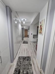a hallway with rugs on the floor and white walls at Romanescu Park Apartament in Craiova