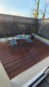a patio with a table and chairs on a wooden deck at " Bulles et Evasion - Maison, Spa en option" in Ville-le-Marclet