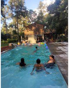 a group of people swimming in a swimming pool at cabaña del teyu in Puerto Cazador