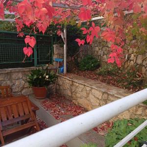 a patio with a bench and a stone wall at River & Garden Apartment in Trebinje