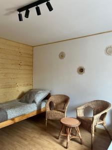 a bedroom with a bed and two chairs at Nad Stawami - studio in Białowieża