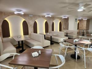 a restaurant with tables and couches and chairs at Hotel Tayrona del Mar in Santa Marta +26 photos