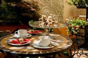 a table with cups and plates of food on it at Honigmond Boutique Hotel in Berlin