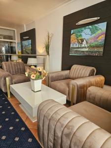 ein Wohnzimmer mit zwei Sofas und einem Tisch in der Unterkunft Hotel von Stephan in Westerland