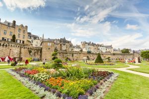 a garden with flowers in front of a castle at - Le Maréchal- Port de Vannes in Vannes