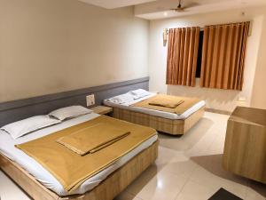 a room with two beds in a room at SD Blueberry Hotel in Shirdi