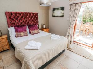 a bedroom with two beds with towels on them at Oak Tree Cottage - Gower in Swansea