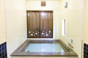 a bath tub in a bathroom with a shower at -貸切別荘-源泉かけ流し温泉 あずみ野ガレージヴィラ-1日1組限定- in Azumino +24 photos
