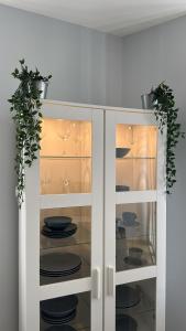 a white cabinet with plates and glasses in it at Casinhas Dom Afonso by Hotel Dom Afonso in Monção +36 photos
