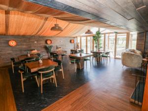 a dining room with wooden tables and chairs at Oak Tree Cottage - Gower in Swansea