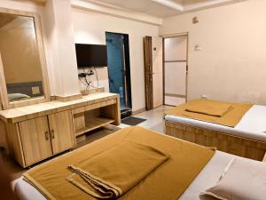 a hotel room with two beds and a mirror at SD Blueberry Hotel in Shirdi +3 photos