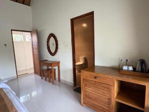 a bathroom with a wooden dresser in a room at Raka Rai Bungalows in Ubud