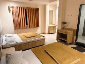 a hotel room with two beds and a bathroom at SD Blueberry Hotel in Shirdi