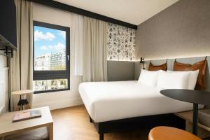 a hotel room with a large bed and a window at Moxy Paris La Villette in Paris +76 photos