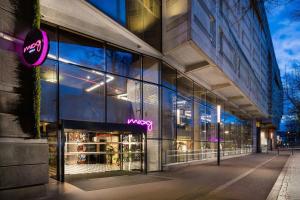 a store front of a building with neon signs in the windows at Moxy Paris La Villette in Paris