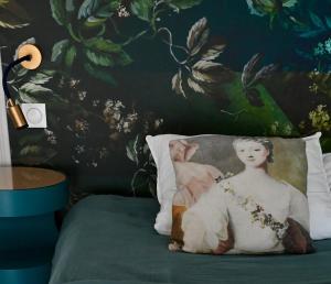 a pillow on a bed with a painting on the wall at Gîte Marangate Numéro 1 in Bazenville +91 photos