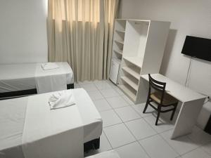 a white room with a desk and a chair at Augustos Hotel in Santo Antônio de Jesus